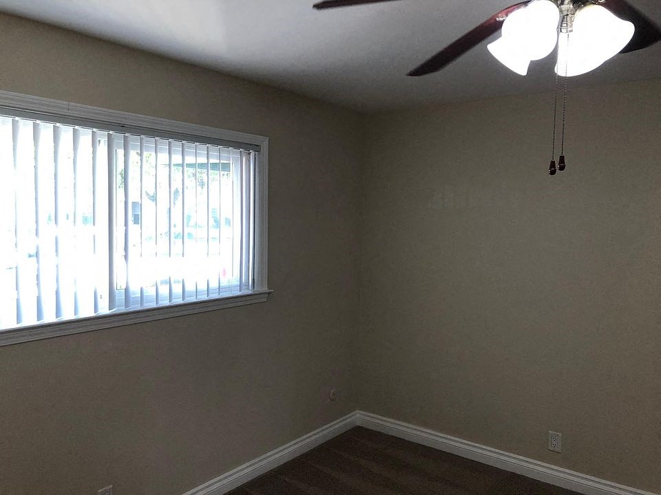 a living room with a window and a ceiling fan