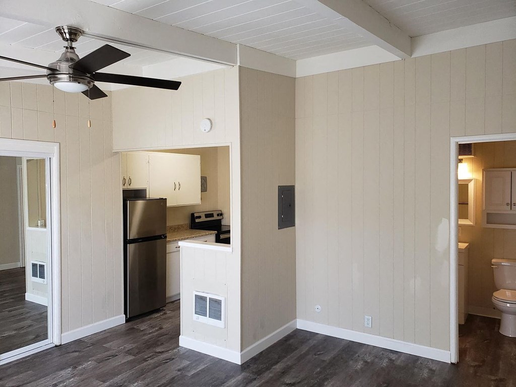 A kitchen with a refrigerator, microwave, and oven.