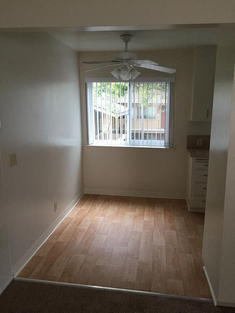 A room with a ceiling fan and a window.