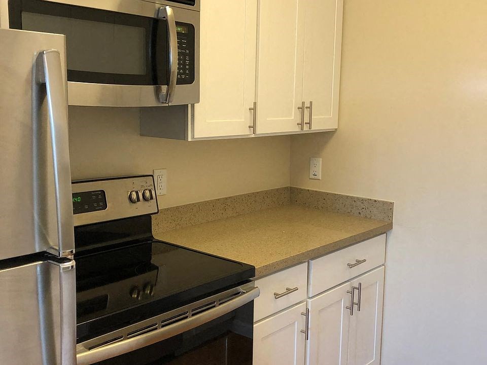 a kitchen with a stove and microwave and white cabinets