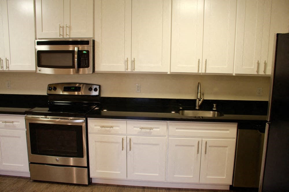 a kitchen with a stove microwave and white cabinets