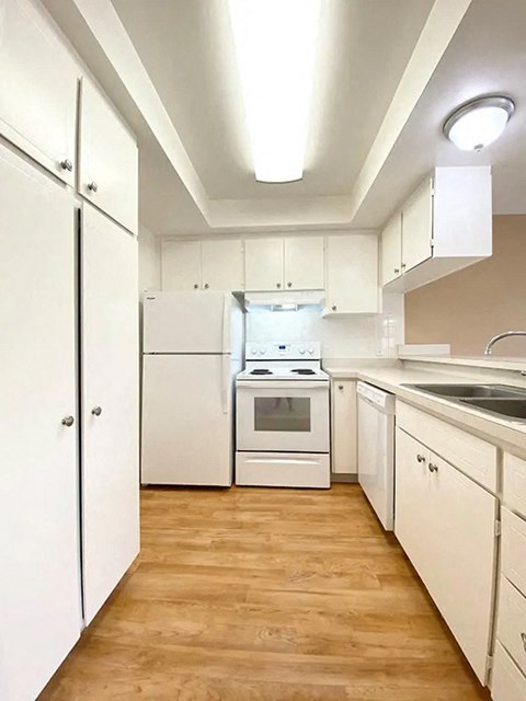 a kitchen with white cabinets and a stove and a sink