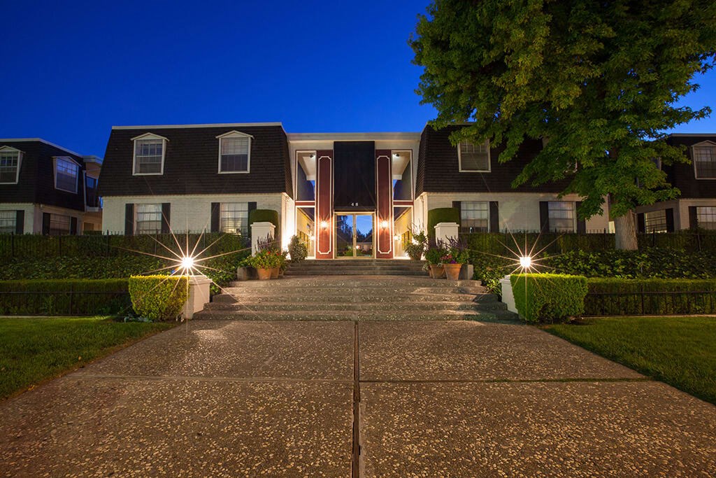 a large house with a driveway in front of it at night