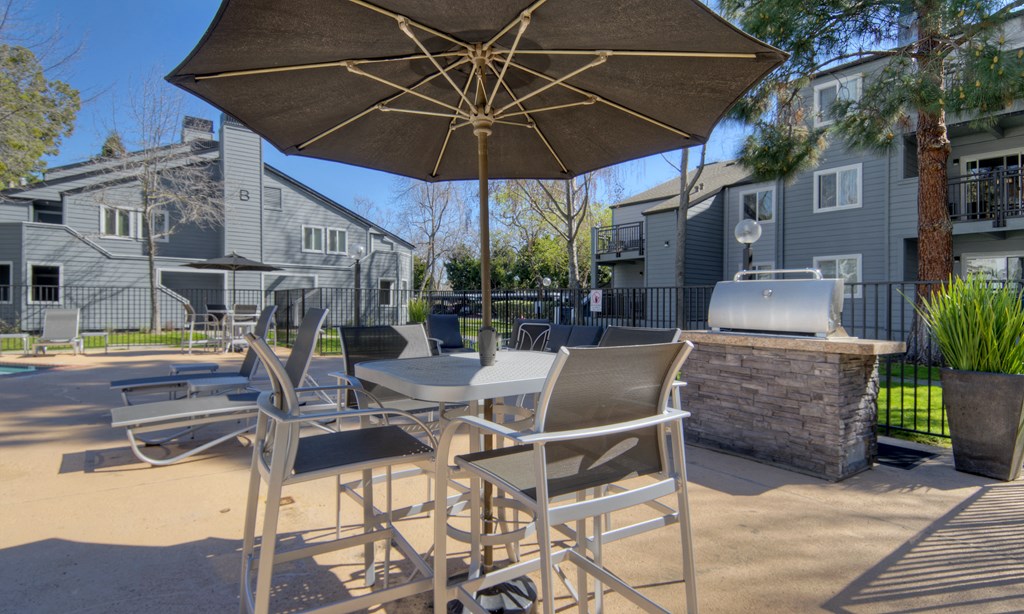 our community has a large patio with tables and chairs and an umbrella