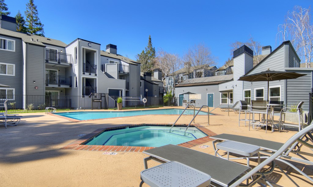 our apartments have a pool and patio with chairs and umbrellas