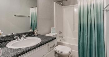 A bathroom with a sink, toilet, and shower.