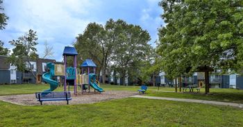 A playground with a green slide and a blue roof.