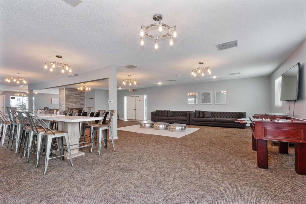 A spacious living room with a pool table and a dining table with chairs.