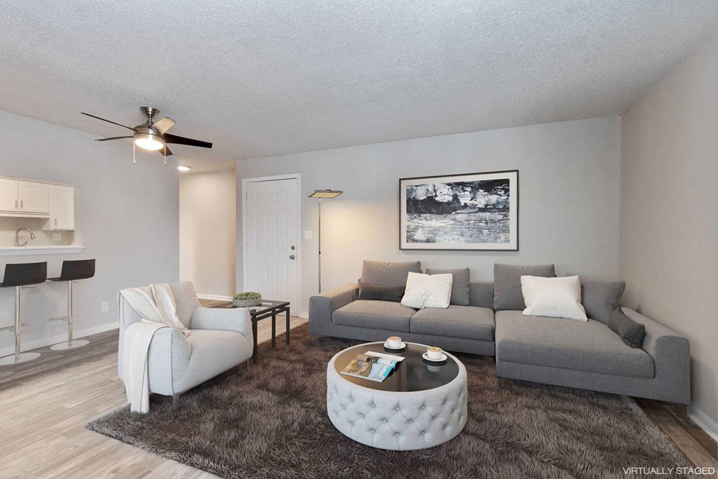 A living room with a grey couch, a white chair, and a coffee table.