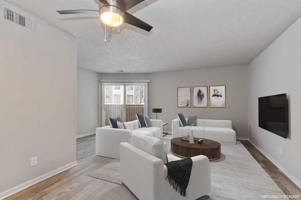 A living room with a white couch and a ceiling fan.