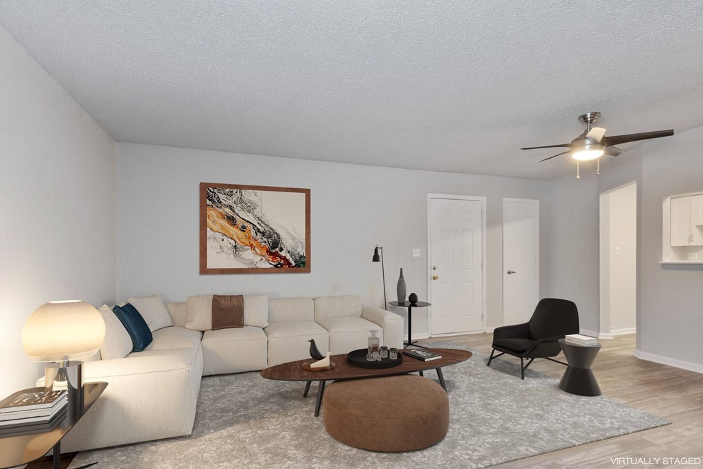 A living room with a white couch, a coffee table, and a painting on the wall.