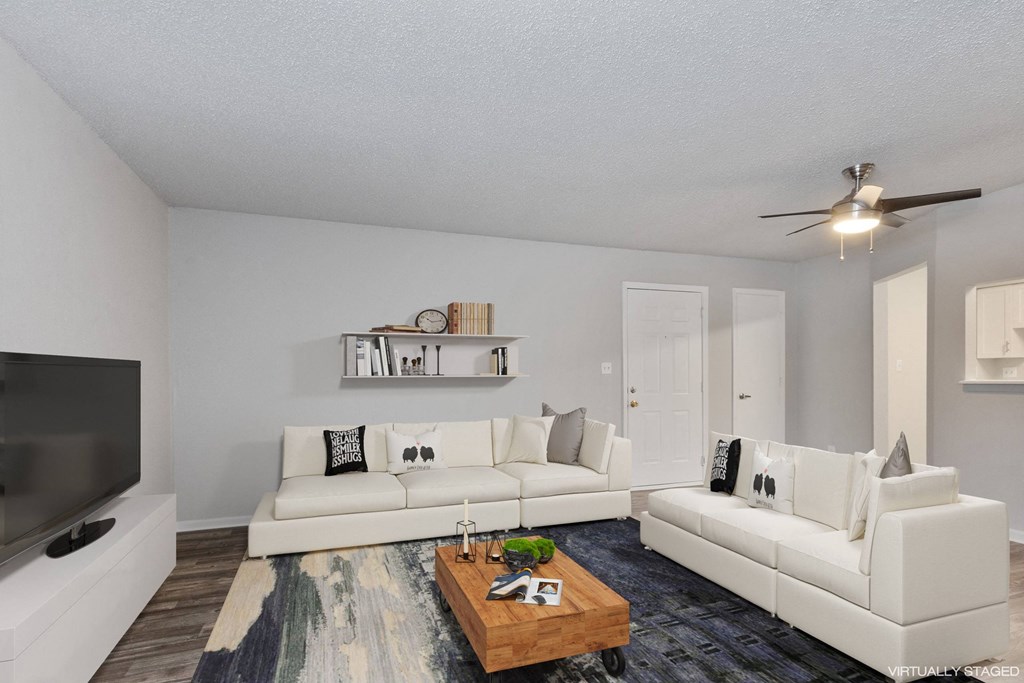 A living room with a white couch and a television.