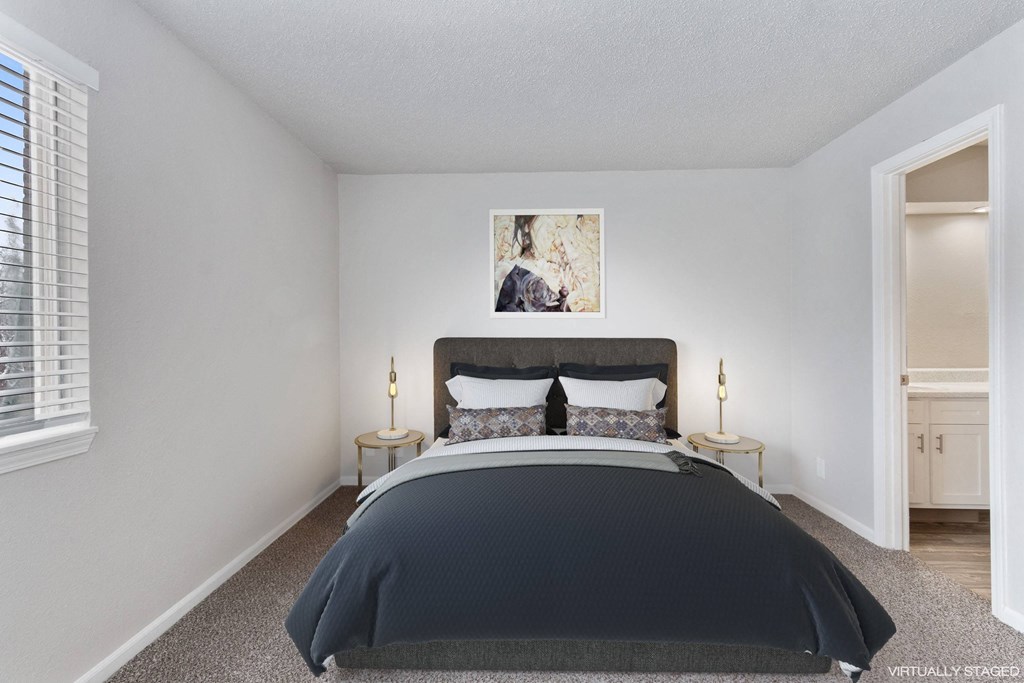A bedroom with a large bed and a painting on the wall.