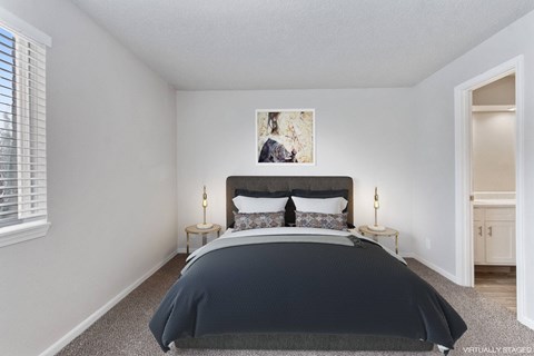 A bedroom with a large bed and a painting on the wall.