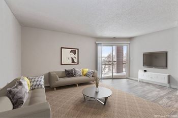 A living room with a grey couch, a coffee table, and a television.