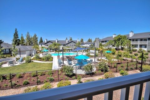 Pool area with lounge seating and green lawn at Rosemeade Apartments, California, 95661