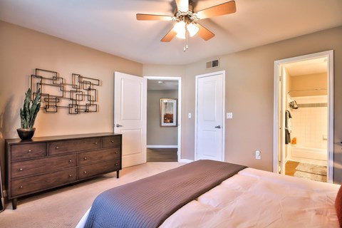 Master bedroom with ensuite and ceiling fan at Rosemeade Apartments, Roseville, CA