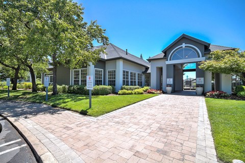 Leasing office entrance with paver walkway and landscaping at Rosemeade Apartments, California, 95661