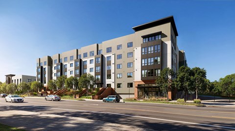 A modern apartment building with cars parked in front.