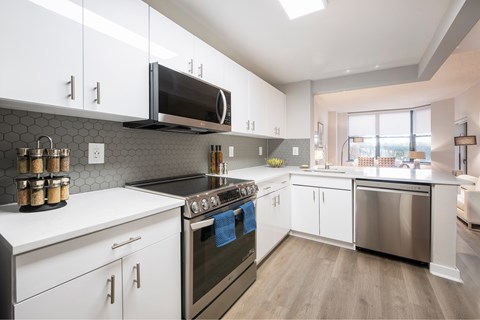 A modern kitchen with white cabinets and stainless steel appliances.