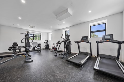 A spacious gym with treadmills, elliptical machines, and other exercise equipment.
