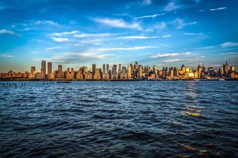 A city skyline is reflected in the water.