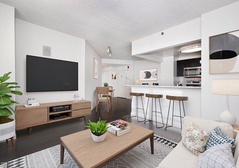 A living room with a wooden coffee table and a flat screen TV mounted on the wall.