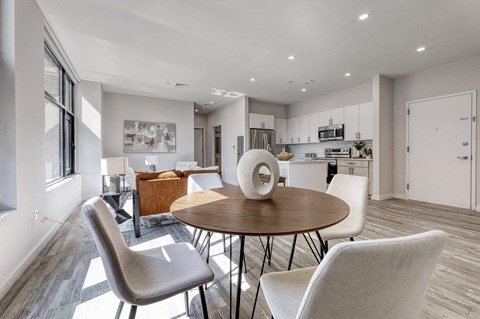 A modern dining room with a round table and chairs.