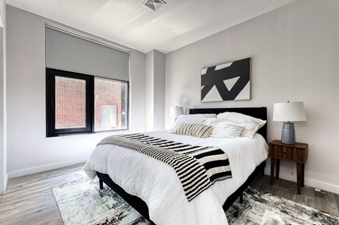 A bedroom with a large bed and a window.