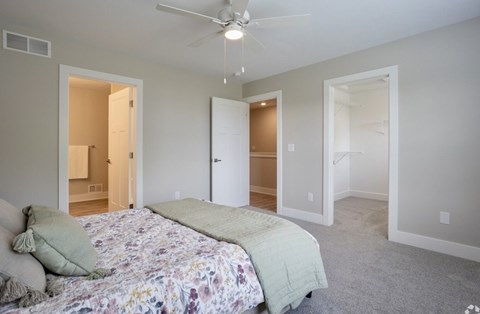 A bedroom with a bed in the center and a ceiling fan above it at Ventura Townhouses, West Olive  , MI, 49460