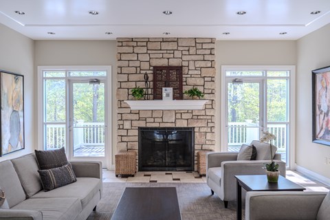 Living room with stone fireplace and tall ceiling at The Vue at Rivertown Park Townhomes Apartments, Wyoming, MI 49418