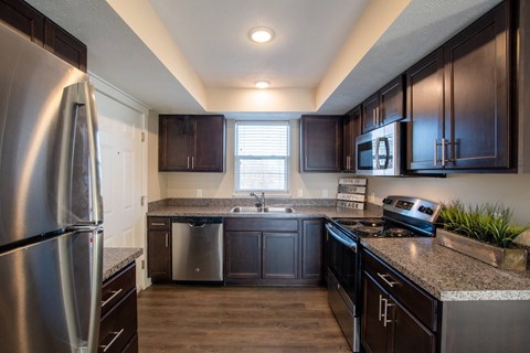 A kitchen with dark wood cabinets and stainless steel appliances.