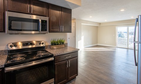 A kitchen with a stove, microwave, and refrigerator.