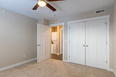 A room with a ceiling fan and a carpeted floor.