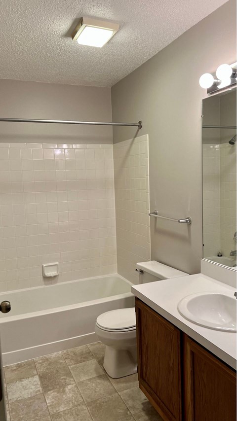A white toilet sits in a bathroom next to a sink.
