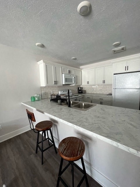 A kitchen with a white counter top and a refrigerator.