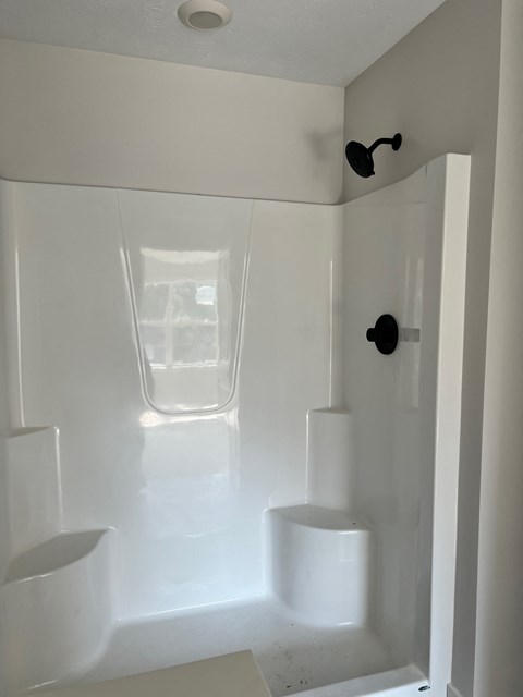 A white bathroom with a glass shower door at Michigan Street Apartment Homes, Grand Rapids  , MI, 49503