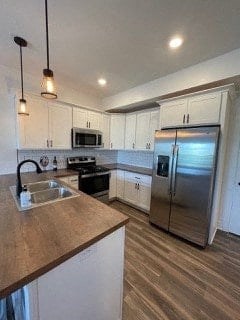 A kitchen with a stainless steel refrigerator and wooden countertops.
