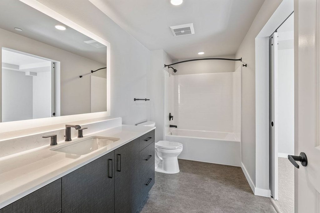 A modern bathroom with shower tub with well it sink