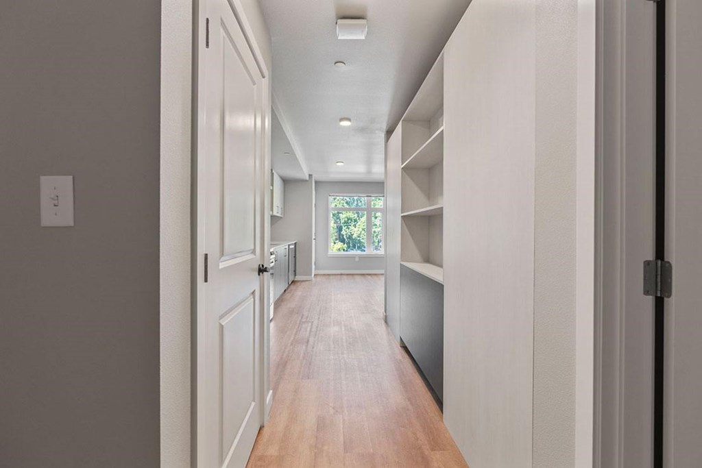 A long hallway with white walls and wood floors