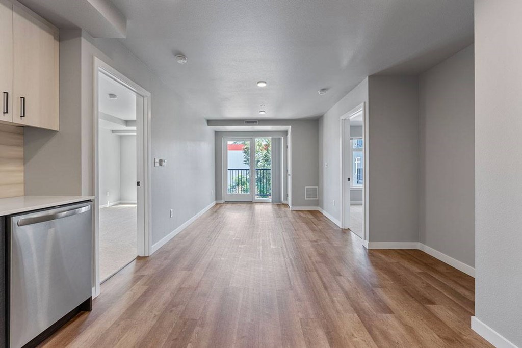 A long, empty hallway with wooden floors and white walls