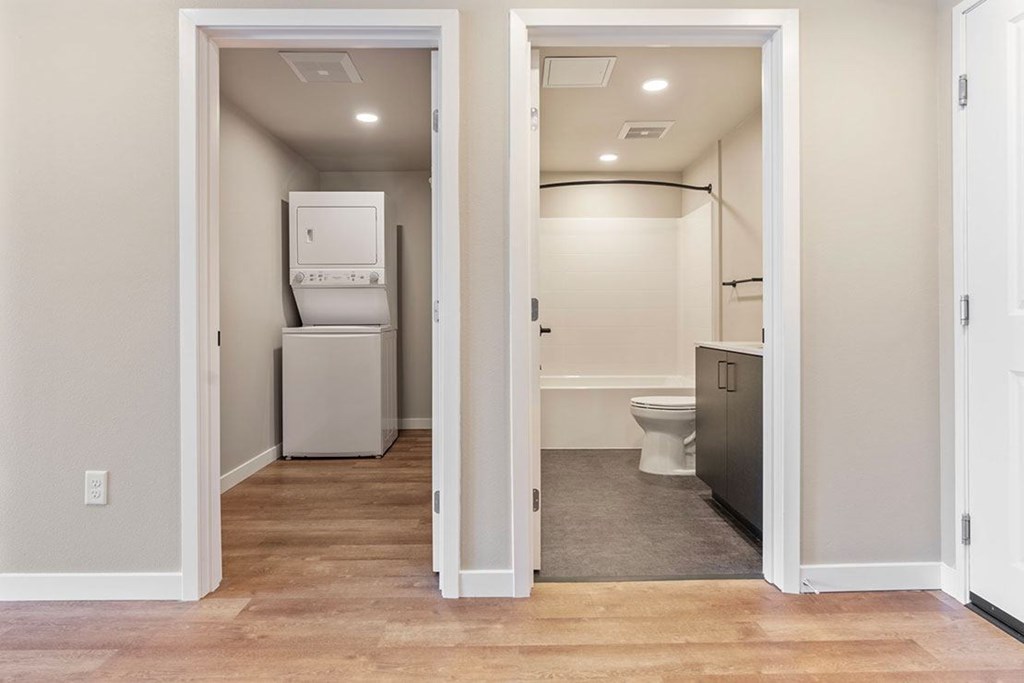 A bathroom with a toilet and a refrigerator in a split bathroom