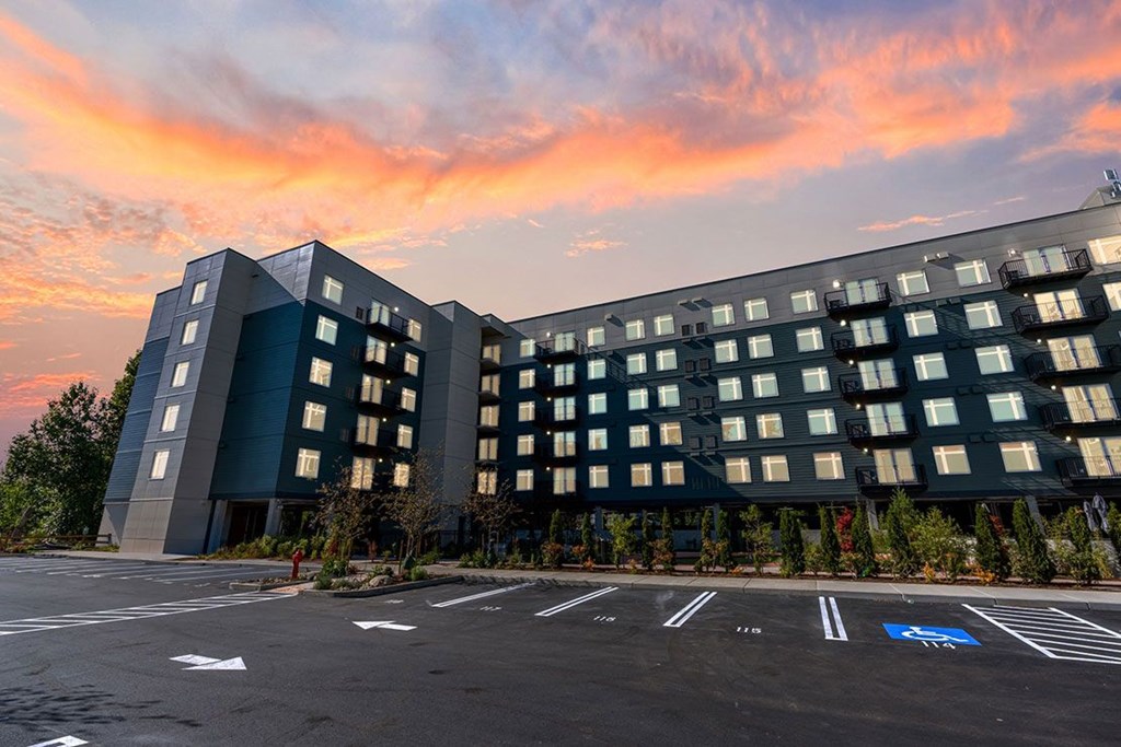 A large, modern building with a parking lot in front of it