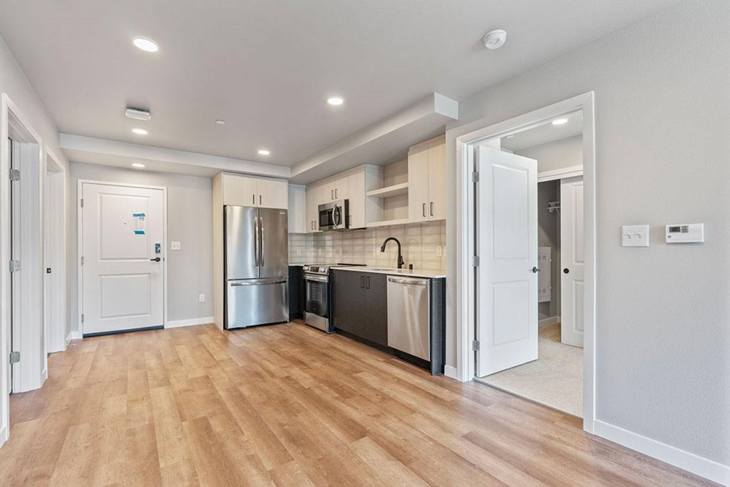 A kitchen with a refrigerator, oven, and microwave