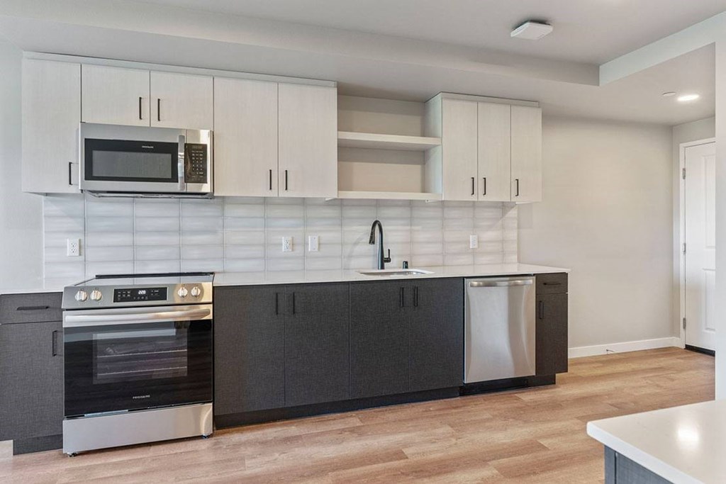 A kitchen with a stove, oven, and microwave