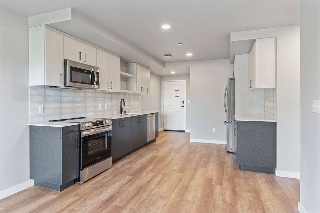 A kitchen with a black oven and wooden floors