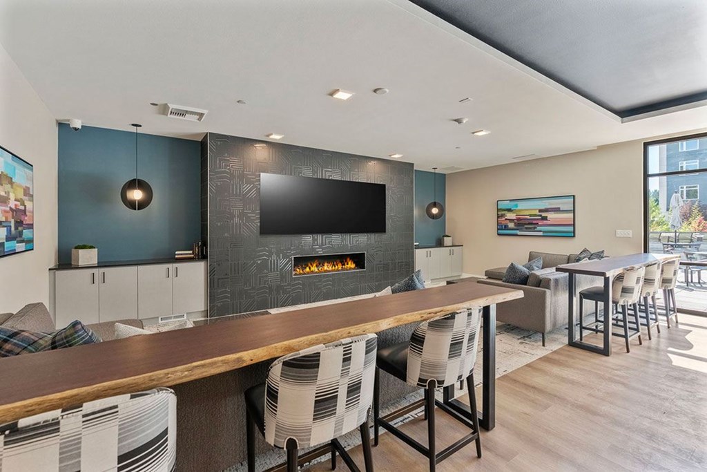 A modern living room with a fireplace and a long wooden table