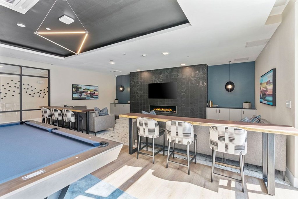 A modern room with a pool table and bar area