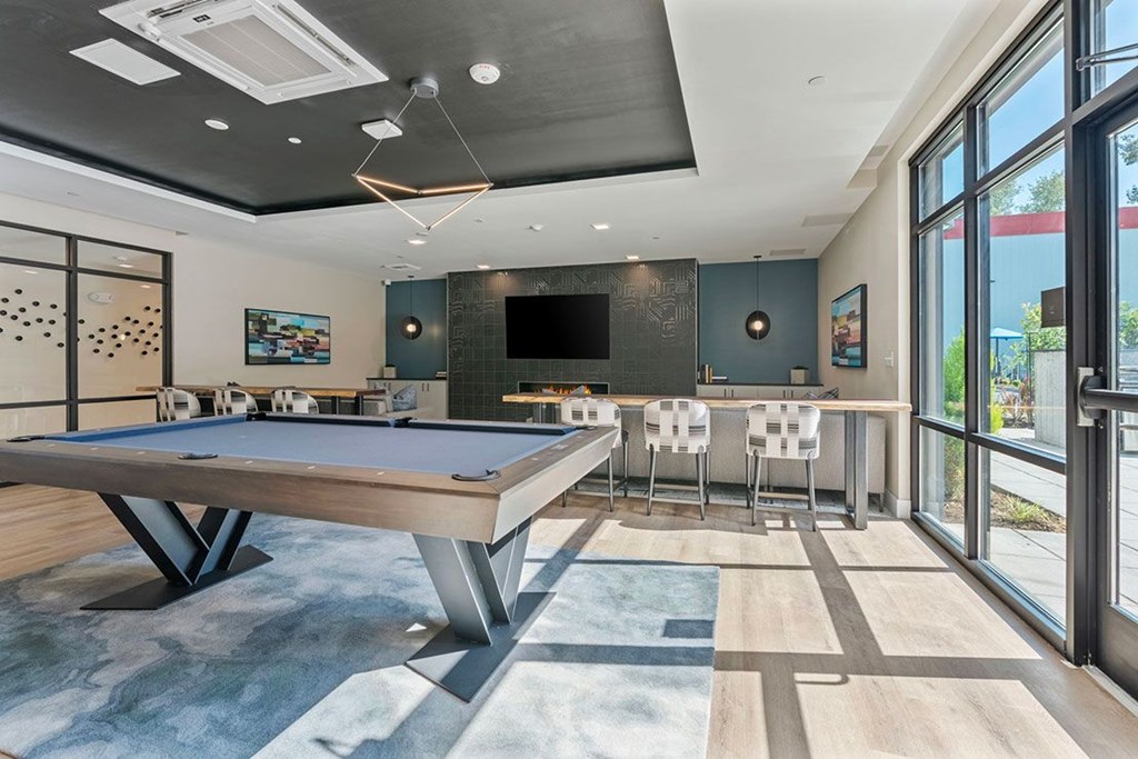 A room with a pool table and television