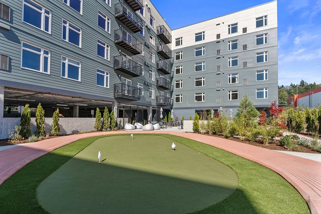 A large grassy area in front of apartment buildings